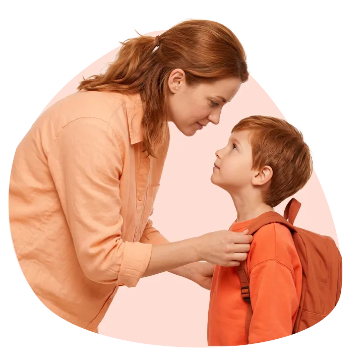 Une mère ajuste le cartable de son fils avant l'école